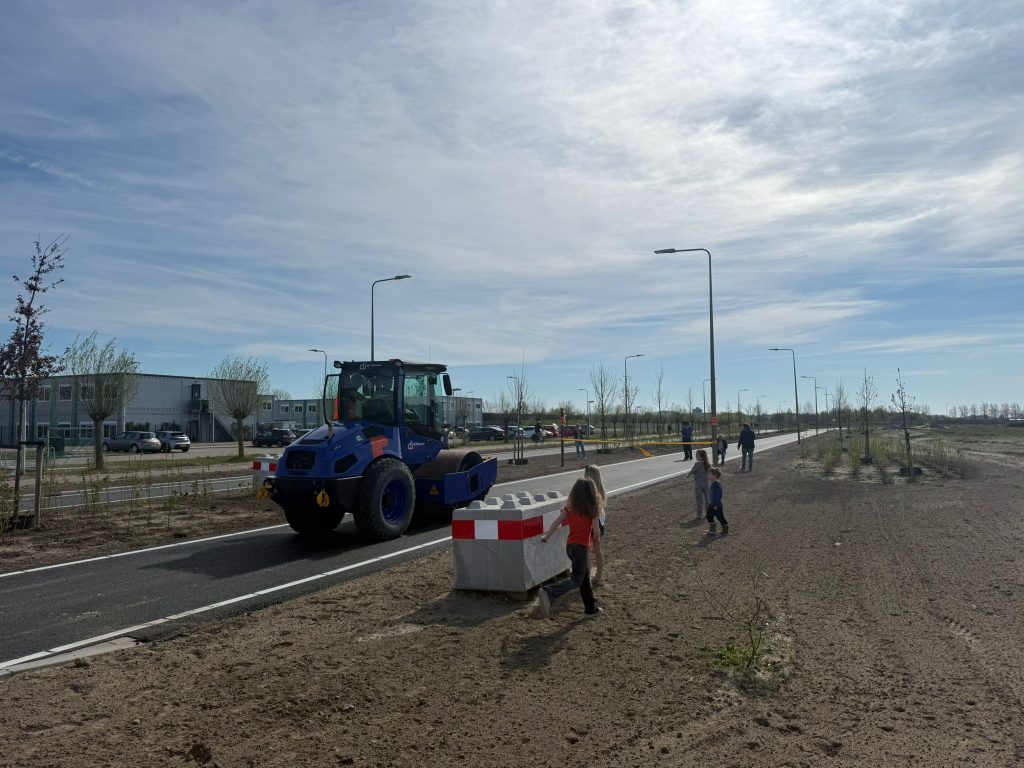 Machine die over de weg rijdt met kinderen op de achtergrond